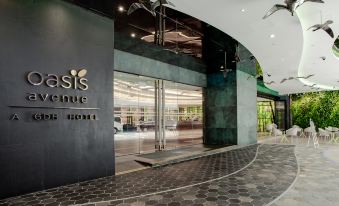 The lobby of the building has an entrance and a sign on its wall indicating that it is a hotel at OASIS AVENUE – A GDH HOTEL