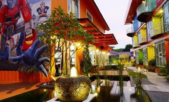 a courtyard with a fountain surrounded by various plants and trees , creating a serene atmosphere at Ppt Muar Hotel