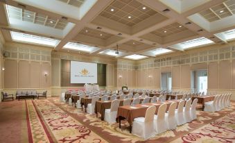 a large , empty conference room with rows of chairs and a podium in the center at Dheva Mantra Resort