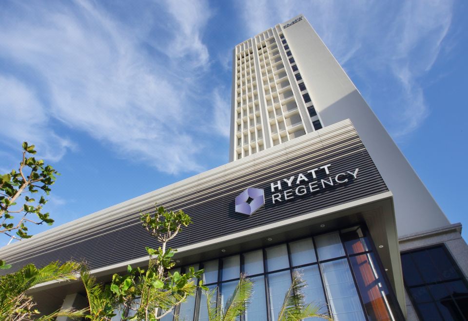 a tall building with a hyatt regency sign on the side , located in a city setting at Hyatt Regency Naha, Okinawa