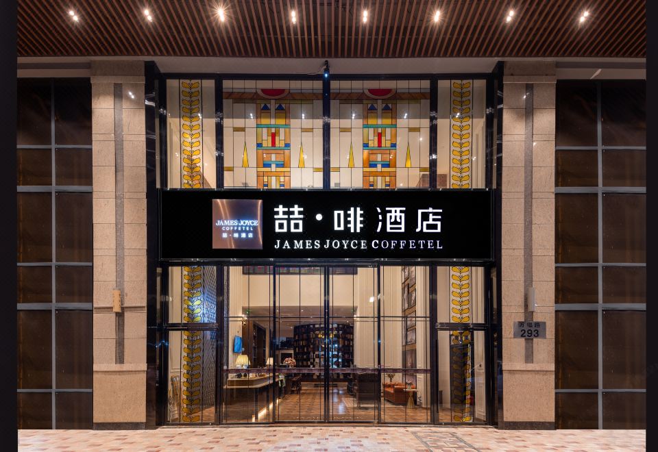 The building entrance is marked by an illuminated sign above it and additional signage on both sides at James Joyce Coffetel Hotel (Guangzhou Beijing Road Metro Station Pedestrian Street)