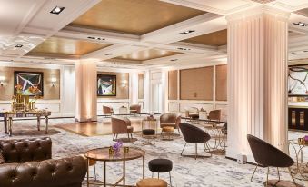 a luxurious hotel lobby with white walls , gold accents , and multiple seating areas filled with comfortable seating at Four Seasons Hotel Madrid