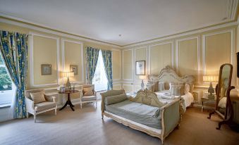 a luxurious bedroom with a large bed , couches , and chairs arranged in a sitting area at Eshott Hall