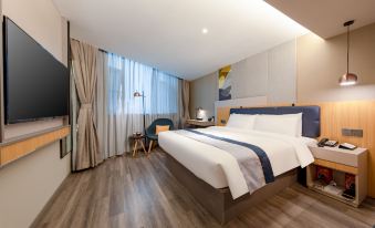 A modern bedroom with a large bed and desk in the middle, alongside an open area at Homeinn Selected (Foshan Zumiao Metro Station)
