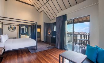 a bedroom with a large bed , a table , and a sliding glass door leading to a balcony at Avani Sepang Goldcoast Resort