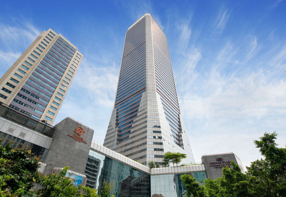 A grand building with towering structures, including a castle-like edifice, is located in a scenic area close to a river at Crowne Plaza Guangzhou City Centre
