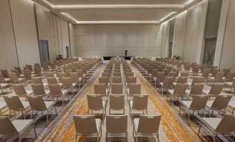 a large conference room with rows of chairs arranged in a semicircle , and a podium at the front of the room at Alma Resort Cam Ranh