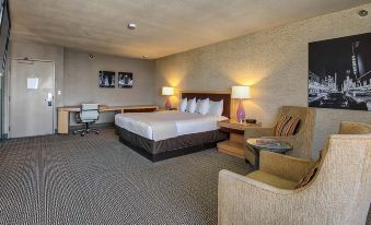 a modern hotel room with a large bed , two nightstands , and a desk , all lit by warm lights at Plaza Hotel & Casino