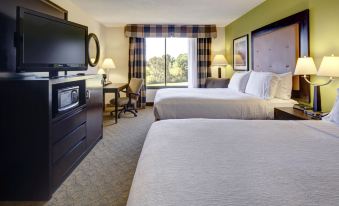 a modern hotel room with two beds , a window , and a tv , all neatly arranged at Holiday Inn Staunton Conference Center