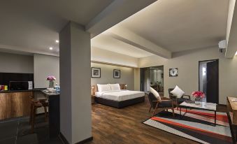 a spacious bedroom with hardwood floors , a large bed , and a chair near the bed at Tropics Eight Suites