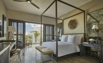a large bedroom with a four - poster bed and a view of the ocean outside the window at Four Seasons Resort and Residence Anguilla