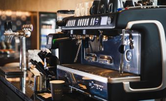 A close-up view of coffee machines and cups in an espresso machine at UrCove by HYATT Hangzhou Westlake