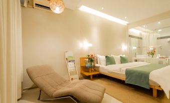 A modern bedroom with a large bed and chair in the middle, as well as another room at Tourism Trend Hotel