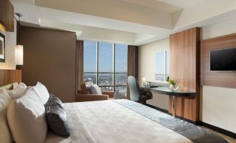 a hotel room with a large bed , a desk , and a window overlooking the city at Best Western Premier la Grande Hotel