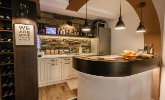 a modern kitchen with a black and white countertop , stone backsplash , and various appliances and condiments at Villa Varosh
