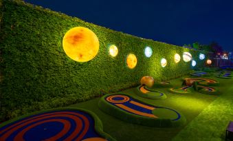 The garden is illuminated at night with lights on the wall, creating a charming atmosphere at Grande Centre Point Space Pattaya