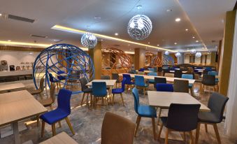 a large , modern dining room with multiple tables and chairs arranged for a group of people at Holiday Inn Express