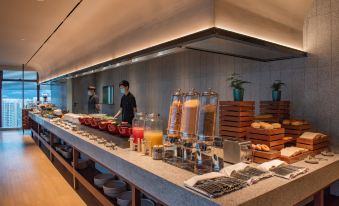 The restaurant offers a wide variety of food options displayed on the counter for customers to choose from at ICON LAB Hotel Shenzhen Futian