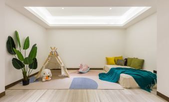 a modern living room with white walls , hardwood floors , and a play area for children at Sanya Haitang Bay Island Villa (International Duty Free City Branch)