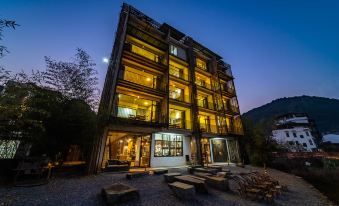 The hotel building is surrounded by greenery in the front at night at Yangshuo Sudder Street Guesthouse