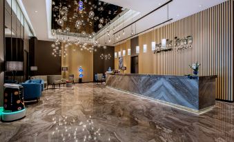 The lobby is adorned with a variety of unique lighting fixtures, including an art deco style at Park Inn by Radisson Beijing Tongzhou Universal Resort