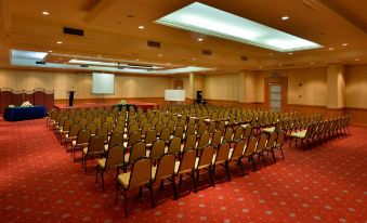 a large , empty conference room with rows of chairs and a projector screen at the front at Pearl View Hotel Prai, Penang