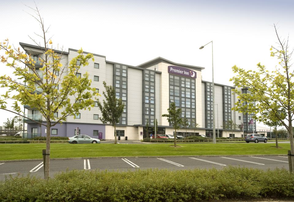 a large hotel building surrounded by trees , with a grassy area in front of it at Dublin Airport
