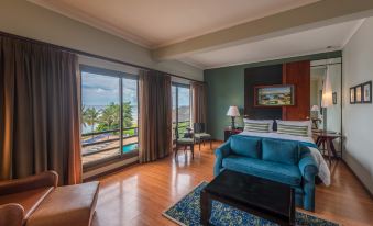 a spacious hotel room with a king - sized bed , a couch , and a large window overlooking the ocean at Sea Cliff Hotel