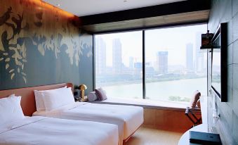 A bedroom with double beds and large windows offering city views at The Macau Roosevelt