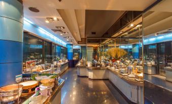 The restaurant features large windows, tables in the middle, and an open concept kitchen at Baiyoke Suite Hotel