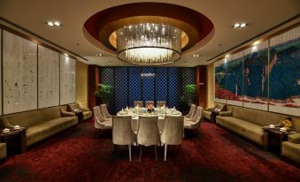 An elegant set of tables and chairs is situated alongside the dining table in a spacious room at Hotel Equatorial Shanghai