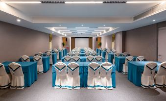 A spacious wedding venue is arranged with blue and white chairs placed on the tables at Homeinn Selected (Foshan Zumiao Metro Station)