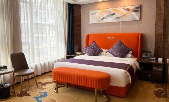 a large bed with an orange headboard is in a room with a window and a chair at Gushi Oriental Earl Hotel (Yucheng Avenue Genqin Culture Park)