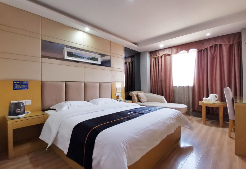 In the middle room, there is a large bed with wood paneling and a white headboard at Yile Hotel
