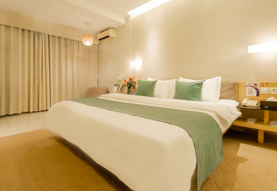 The bedroom features a large bed with a white and brown color scheme, as well as an open at Tourism Trend Hotel