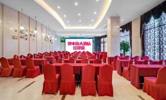 a large conference room with red tables and chairs , a screen at the front , and chinese characters on the wall at Mediterranean Hotel