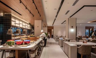 The restaurant features an open concept design with tables, chairs, and a counter at UrCove by HYATT Shanghai Jing'an
