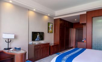 The bedroom in the apartment or bedroom features a large bed and a TV, along with wood paneling at Kela Hotel