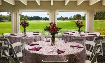 a dining room with tables covered in purple tablecloths and chairs arranged around them , creating a festive atmosphere at Grand Palms Spa & Golf Resort