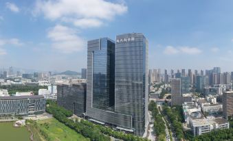 A large building with numerous windows and a central office tower on the upper level at Crystal Orange Shenzhen Nanshan Science and Technology Park Hotel