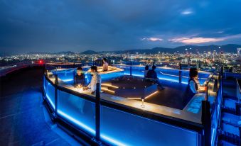 a group of people gathered around a dining table on a rooftop , enjoying the view at Kobe Portopia Hotel