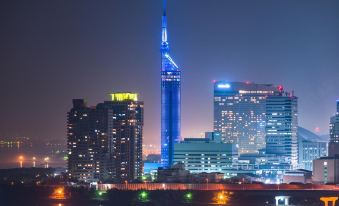 a city skyline at night , with the oriental pearl tower illuminated in blue and surrounded by other buildings at Hotel Monte Hermana Fukuoka