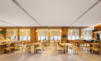 The restaurant features spacious windows and tables in the center, accompanied by an unoccupied dining area at Vienna International Hotel (Baoting Center)