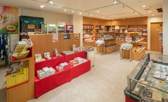 a store filled with various items , including books and candles , under bright lights and ceiling beams at Kamenoi Hotel Atami Annex