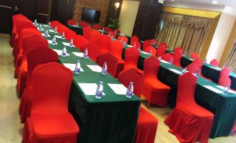 a conference room with red chairs and green tables , ready for a meeting or event at Diamond Hotel