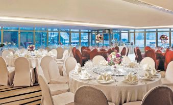A room with large windows and tables set for an event or wedding reception at The Royal Pacific Hotel and Towers