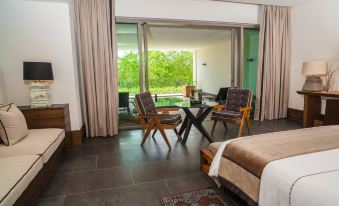a hotel room with a large window , a bed , and several chairs and a dining table at Nizuc Resort & Spa