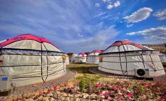 A collection of tents positioned in various directions, with the sky as the backdrop at Colorful Danxia Yimi Sunshine Inn