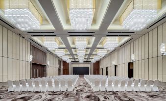 A spacious ballroom is arranged with rows of chairs for an event at the hotel at Pullman Oceanview Sanya Bay Resort & Spa
