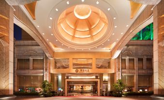 a large hotel entrance with a large dome ceiling and potted plants in front of it at Golden Hotel